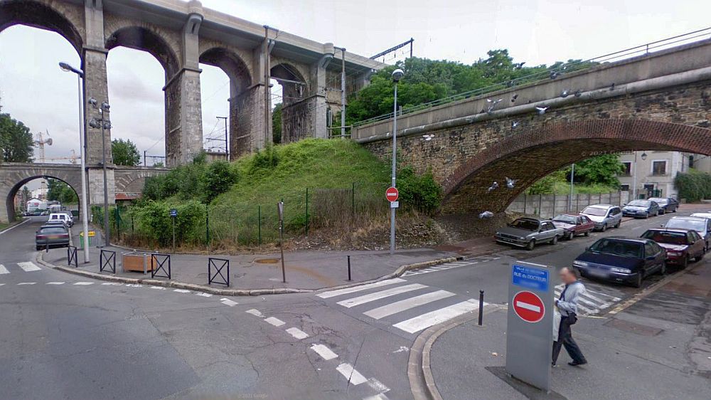 Scene showing the junction where the roads and two viaducts (one at low level and the other at high level) pass over each other. A man is about to walk over the adjacent crossing. This scene is from 2008.