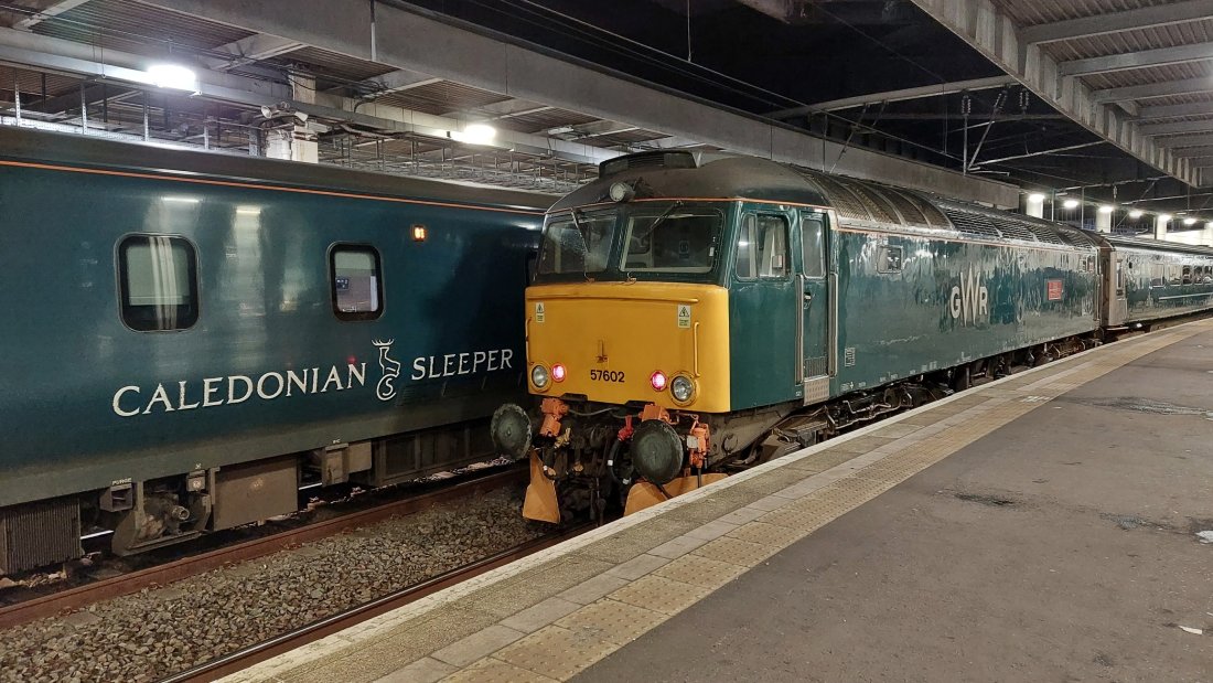 Class 57 Restormel Castle along side the Caledonian Sleeper. The name of the latter can be see on the coach's side. Interestingly due to the light ambience here both trains look quite similar in colour livery!
