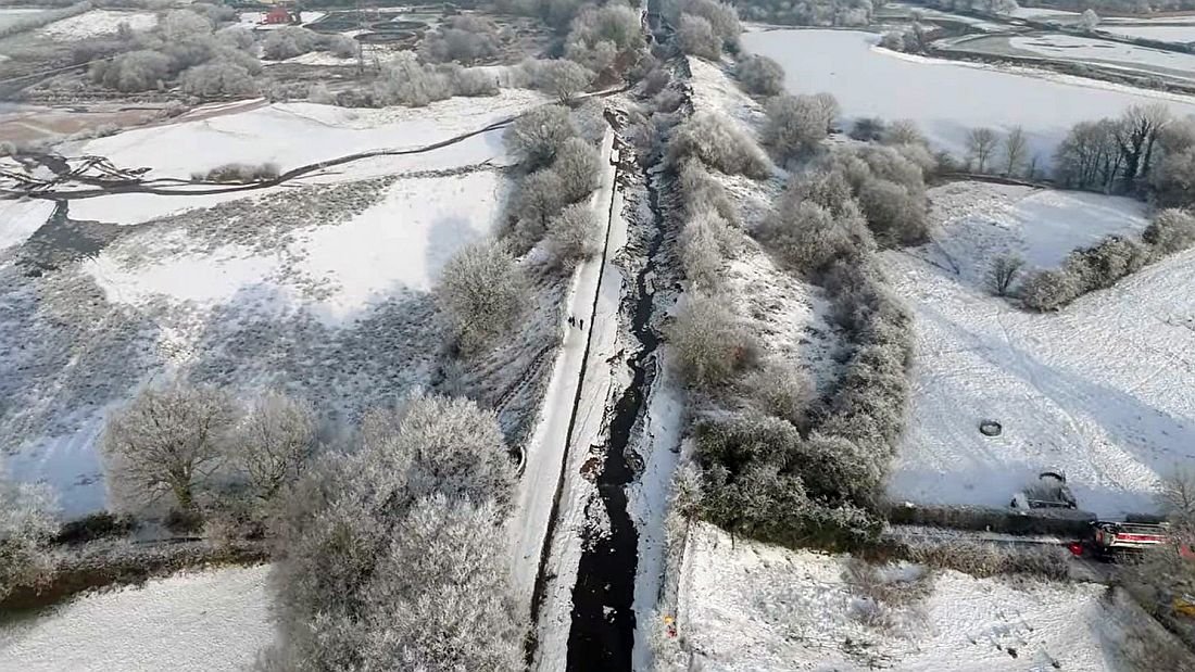 Aerial view of the Bridgwater canal where the breach took place. The empty canal can be seen running down the middle, clearly marked by the snow that surrounds it.