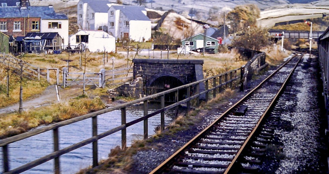 View of the Diggle end of the canal tunnel in 1981. The scenery is much changed now the tunnel has reopened to boating. The semaphore signals that can be seen have log gone as has the siding that was once parallel to the canal.
