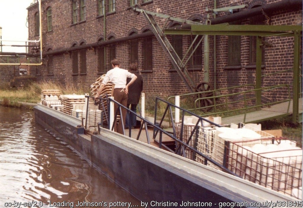 Workmen can be seen loading the canal barge with pottery from the factory which is sited right next to the canal. A ramp can be seen to the right which connects directly from the factory floor to the boat itself.