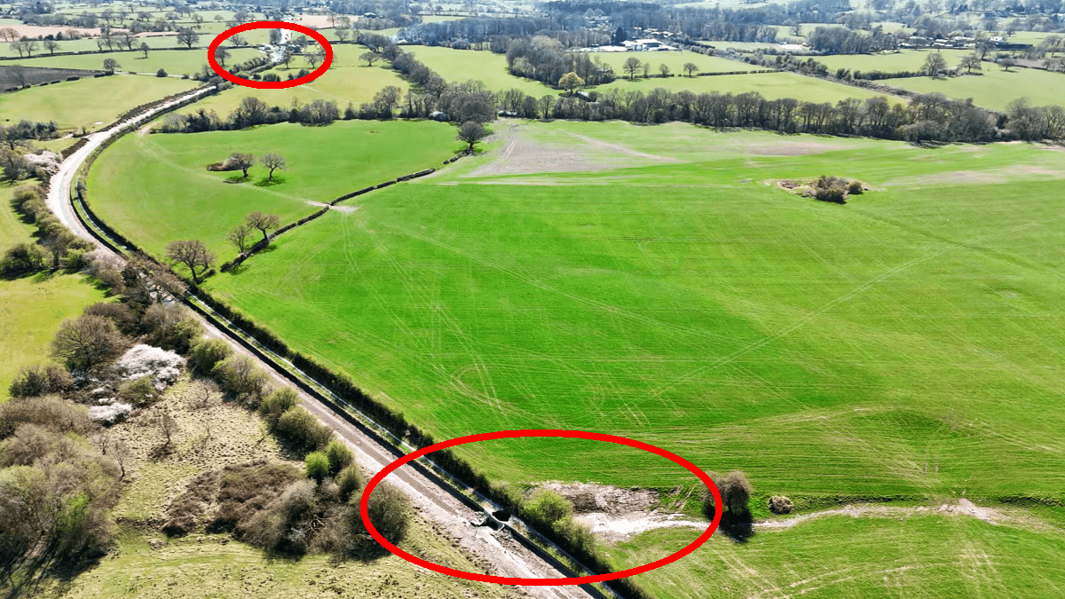 Aerial view showing the empty Macclesfield canal summit level above Boseley locks. The lower part of the image has a ring which marks the area of the actual breach whilst the upper part has a ring marking where the top of the canal locks are.