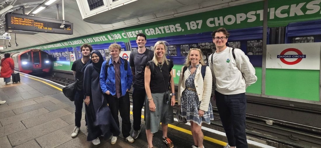 The team behind the Ecover advert. Names not known but its a group of seven designers stood on the platform with their advert behind. A Victoria line train is just arriving and can be seen at left.