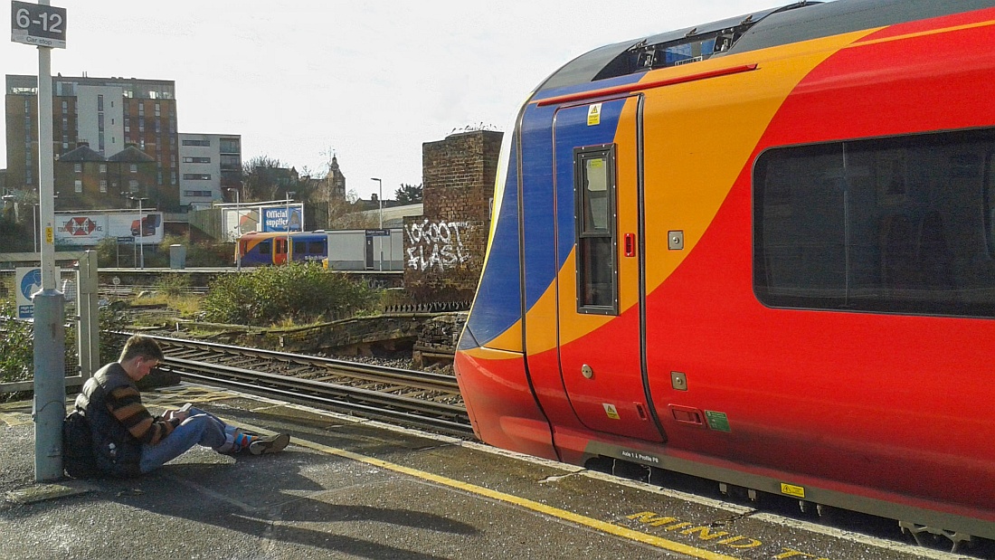 707014 at Clapham Junction with someone enjoying a rest at the end of the platform! At first I thought he was a train spotter!
