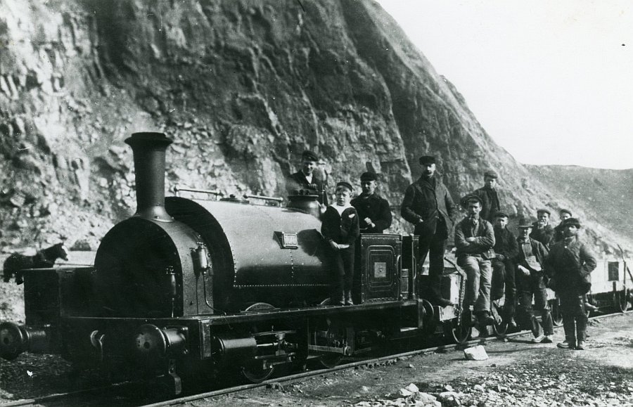 Gang workers pose by one of the locomotives at the Cauldon Low quarries. These locomotives were quite similar to the famous narrow gauge Welsh quarry locomotives. A horse can just be seen on the left.