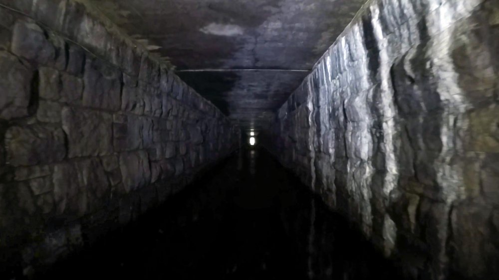 View of the canal tunnel as it passes under what was once Diggle station. The Transpennine main line passes over at this point and the newer concrete raft over the canal is quite evident. The sides of the tunnel are original from when the railway was built.